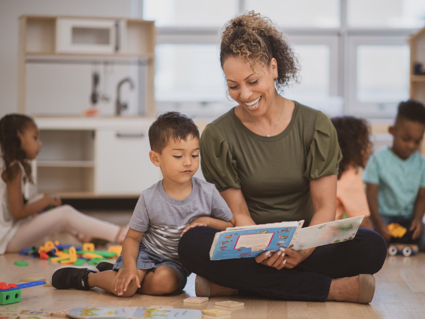 Teacher reading to young child in classroom.