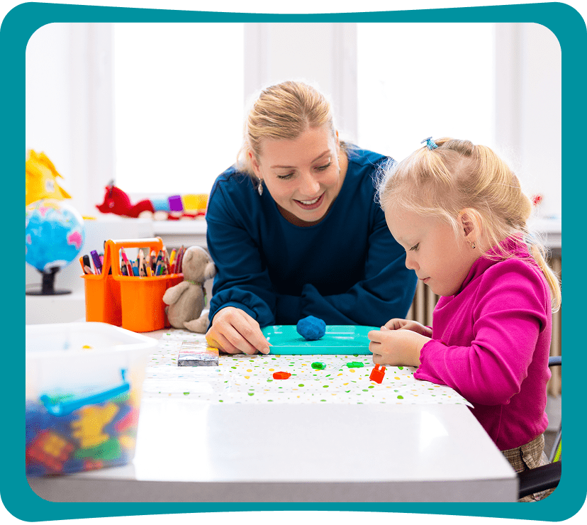 Teacher helping child with arts and crafts.