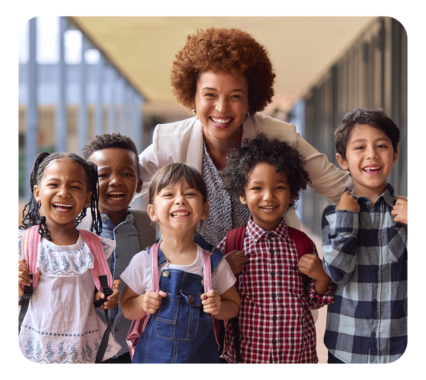 Teacher and smiling children with backpacks.